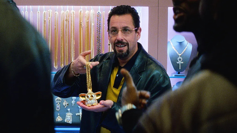 Howard showing off a diamond Furby necklace in Uncut Gems