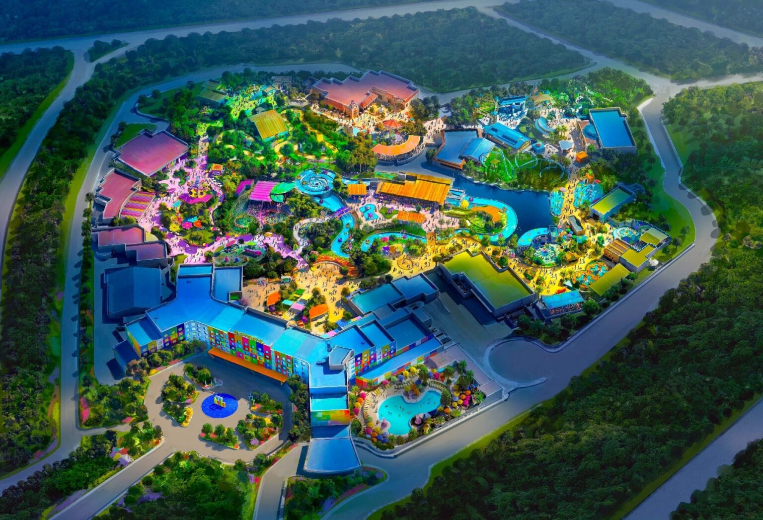 Aerial view of the colorful, illuminated Universal Kids Resort, nestled among dense green trees and winding roads.