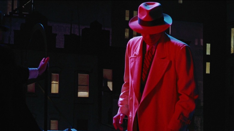 Warren Beatty's Dick Tracy looks down at the floor as he's illuminated by red light in Dick Tracyjpg