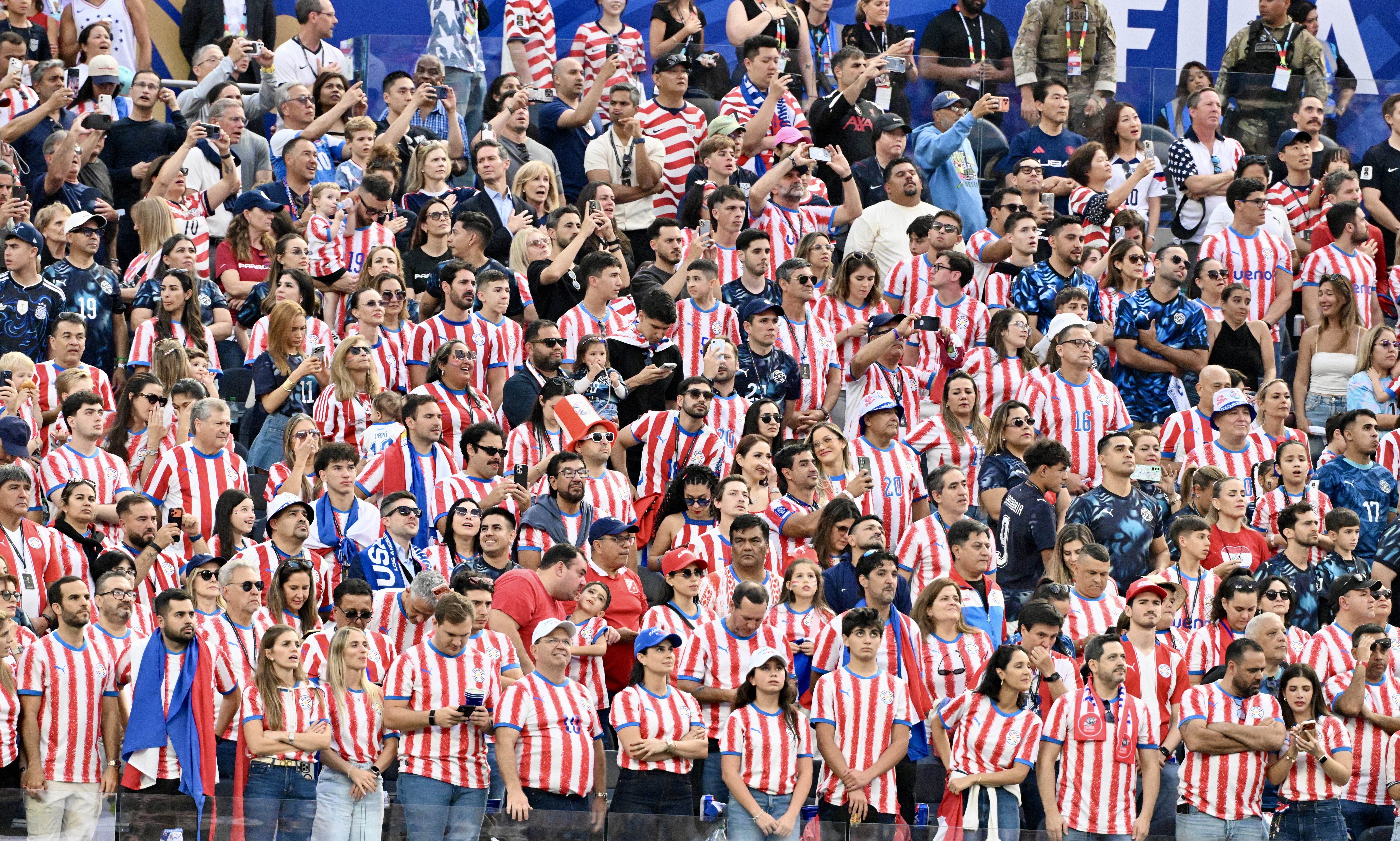 Fans look on during the national anthem prior to a...