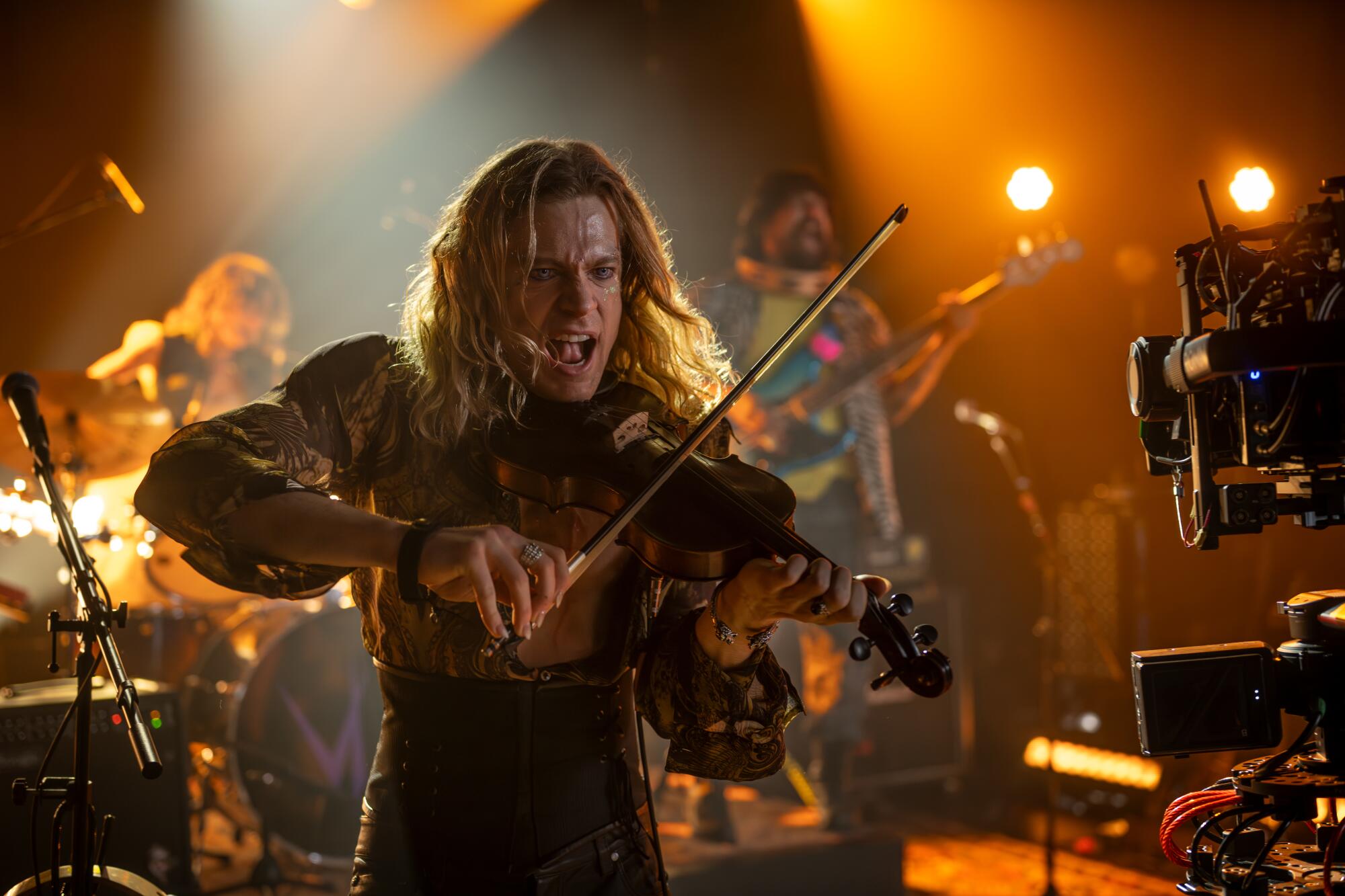 A rock star playing a violin during a live rock concert