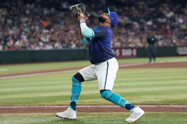 Arizona Diamondbacks first baseman Carlos Santana catches a fly ball in the fifth inning of a baseball game against the Atlanta Braces, Friday, April 3, 2026, in Phoenix. (AP Photo/Rebecca Noble)
