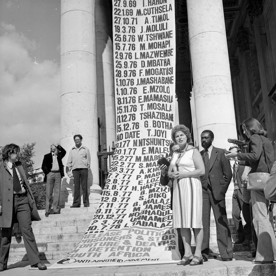  British Labour MP Joan Lestor attends a memorial service for Steve Biko at St-Martin-in-the-Fields, Trafalgar Square, London, to mark the anniversary of the Anti-Apartheid activist's death in detention in South Africa. Draped from the church is a list of 50 other prisoners known to have died in South African detention