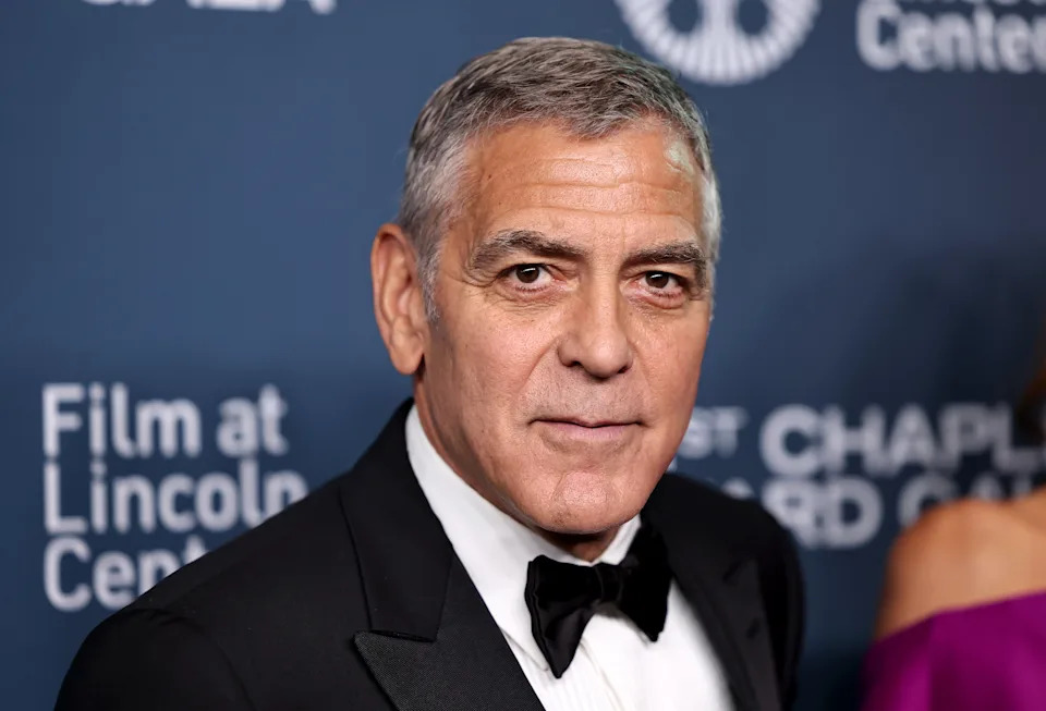 A person in a tuxedo at a formal event, standing in front of a backdrop with text about the Film at Lincoln Center