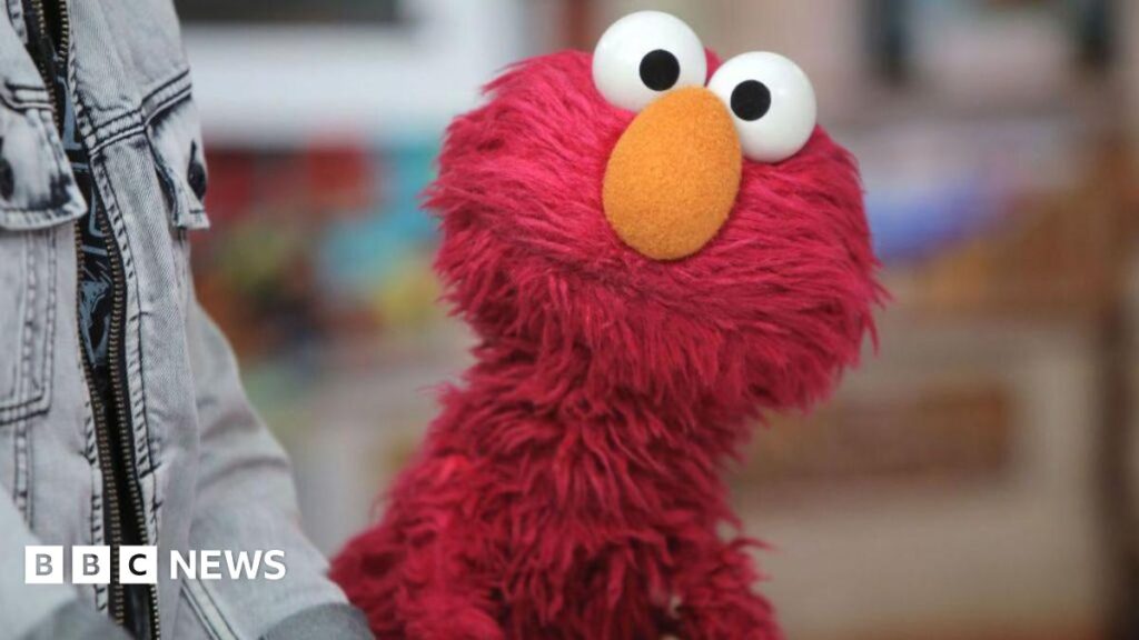 Red puppet Elmo stares into the camera