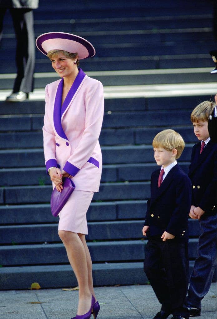 Princess Diana, accompanied by her sons, Prince Harry and Prince William to a special service for fire brigade veterans at St Paul's Cathedral. The Princess is wearing a pink and purple suit designed by Catherine Walker. 