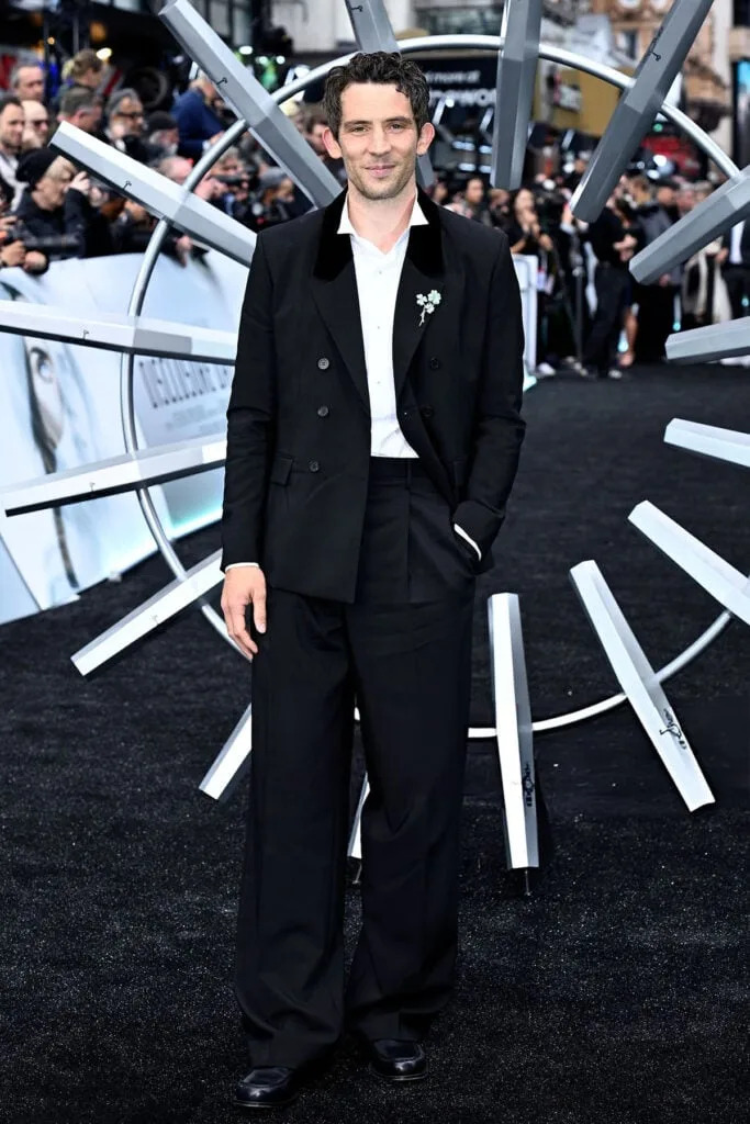 Josh O'Connor wearing a black tailored suit with a shamrock brooch at the Disclosure Day premiere in London.