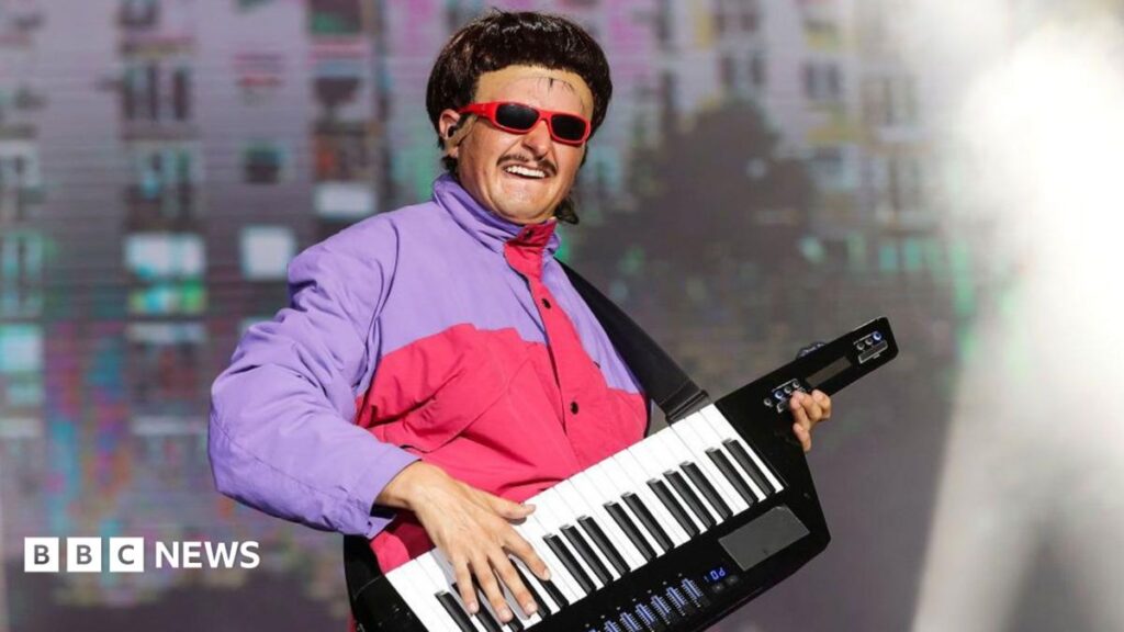 Late singer Oliver Tree’s body returned to US after Brazil helicopter crash Picture of Oliver Tree in a purple and pink jacket performing in 2024. He is holding a keyboard.
