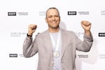 Portland chef Ryan Roadhouse holds up his fists in a victory pose while wearing his newly won James Beard award medal around his neck.