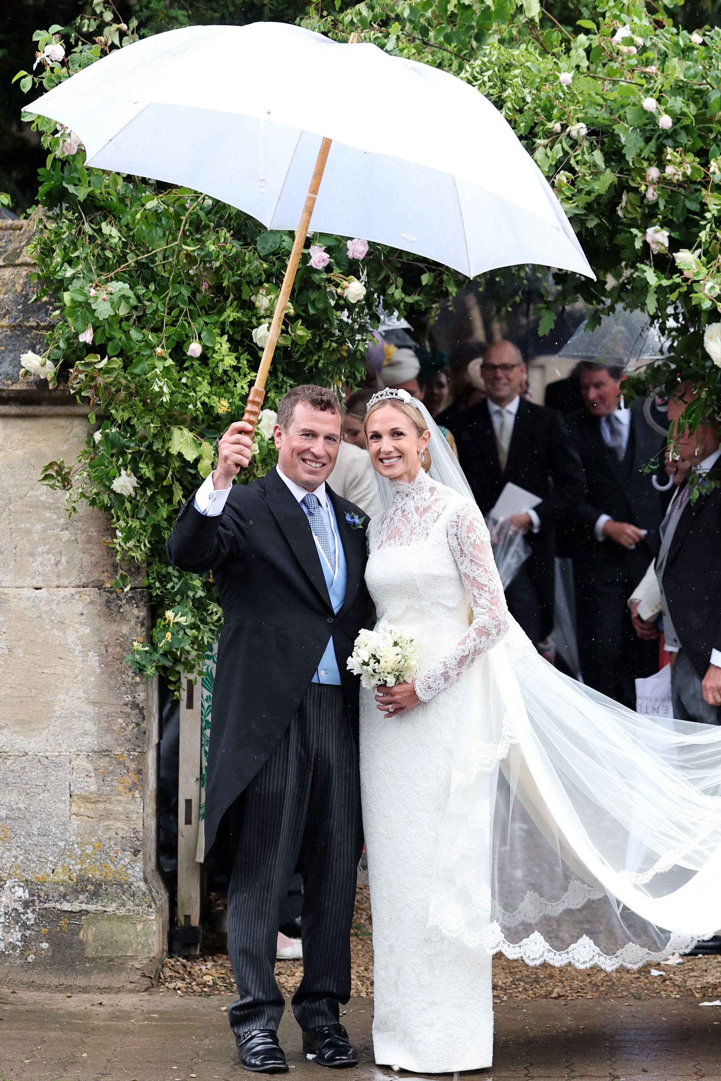 Peter Phillips holding an umbrella over his and Harriet Sperlings head outside the church 