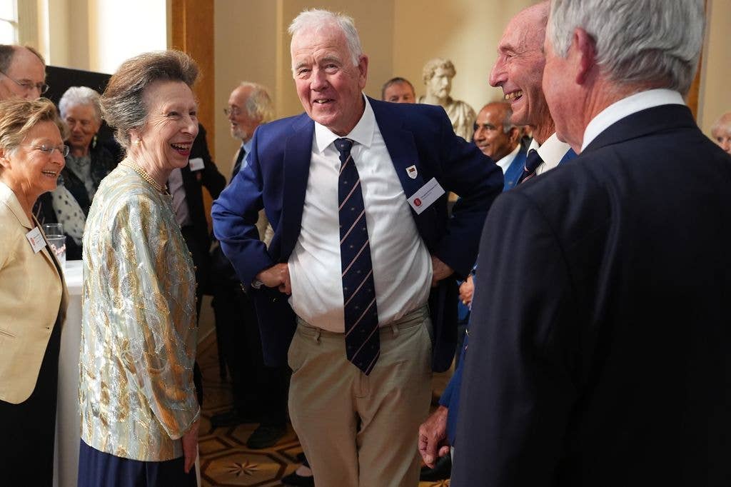 Princess Anne in a metallic jacket talking to guests at a reunion of the 1976 Olympic Games