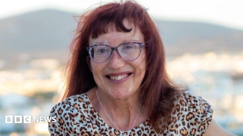 A woman with red hair, who is wearing eye glasses and a leopard print dress.