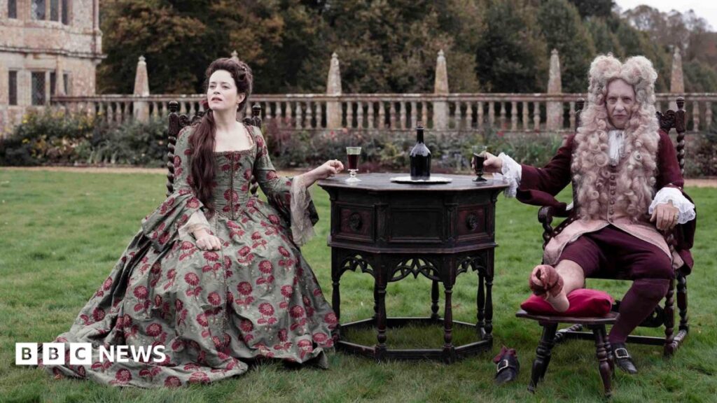 Savage House director ‘fought tooth and nail’ to film in Somerset Claire Foy and Richard E Grant starring in Savage House sit on a lawn in front of Montacute House in Somerset wearing period dress.