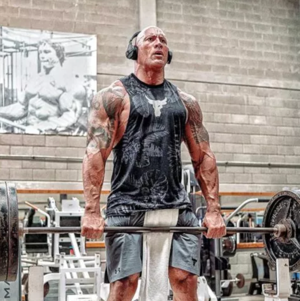 a muscular individual performing a deadlift in a gym setting