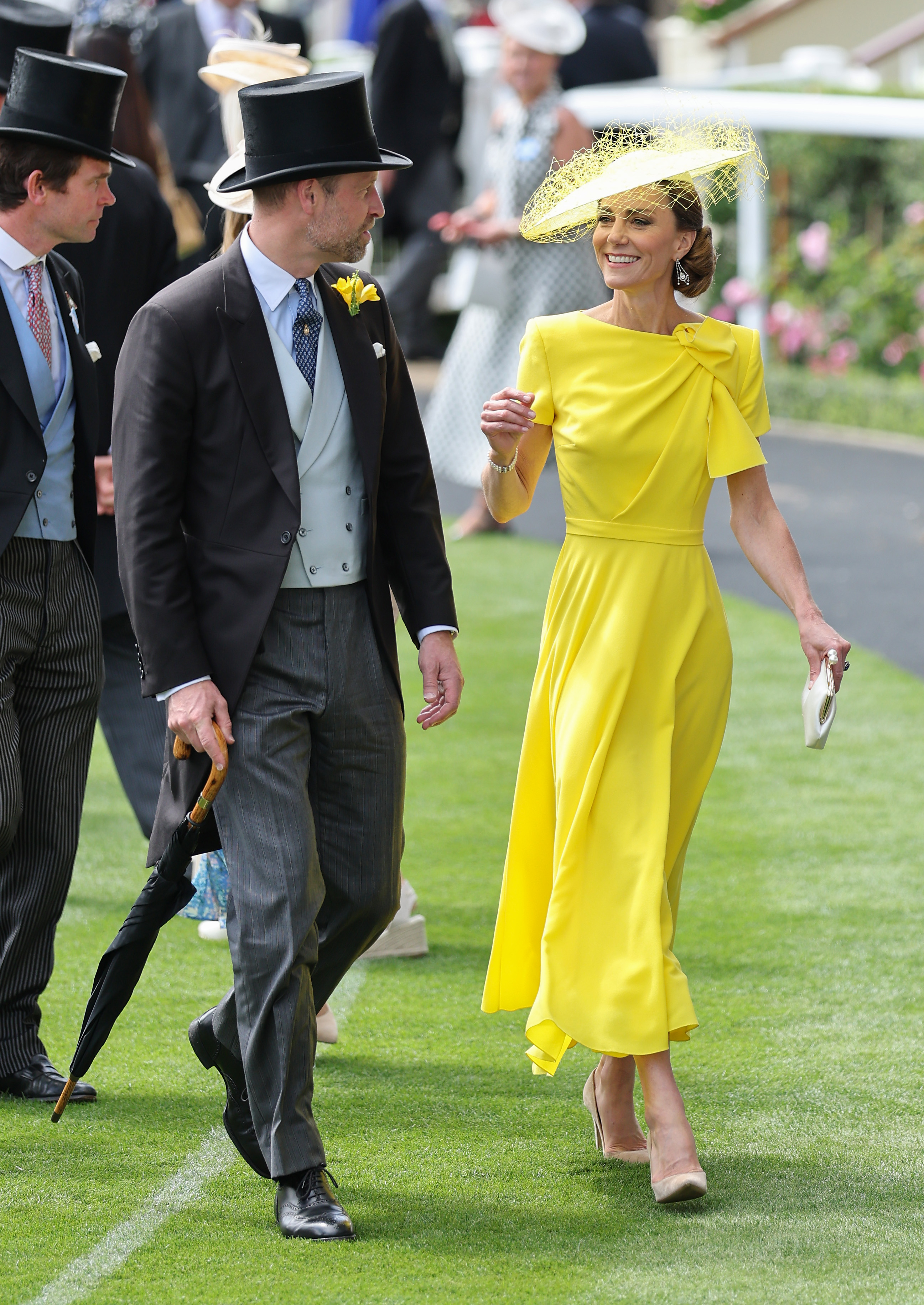 Princess Kate wearing a bright yellow dress and a matching hat for Royal Ascot Day 2 in 2026, while Prince William wears a traditional suit with a top hat
