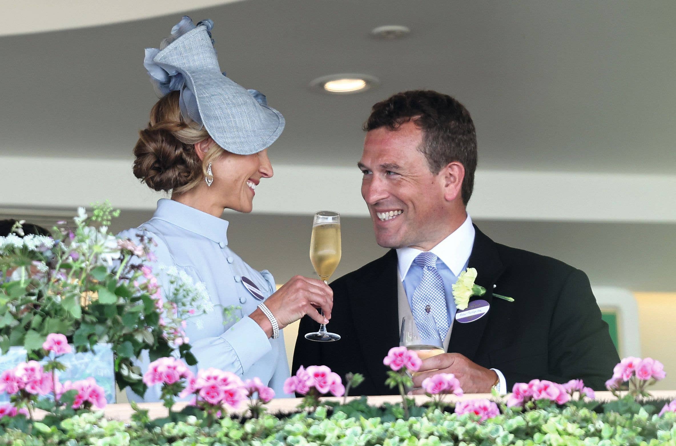 : Harriet Phillips and Peter Phillips smile and drink champagne 