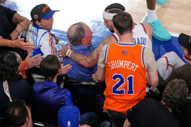 New York Knicks guard Jose Alvarado (5) speaks with former New York City Mayor Michael Bloomberg after falling into him during the second half of Game 3 of the NBA Finals basketball series, Monday, June 8, 2026, in New York. (AP Photo/Yuki Iwamura)