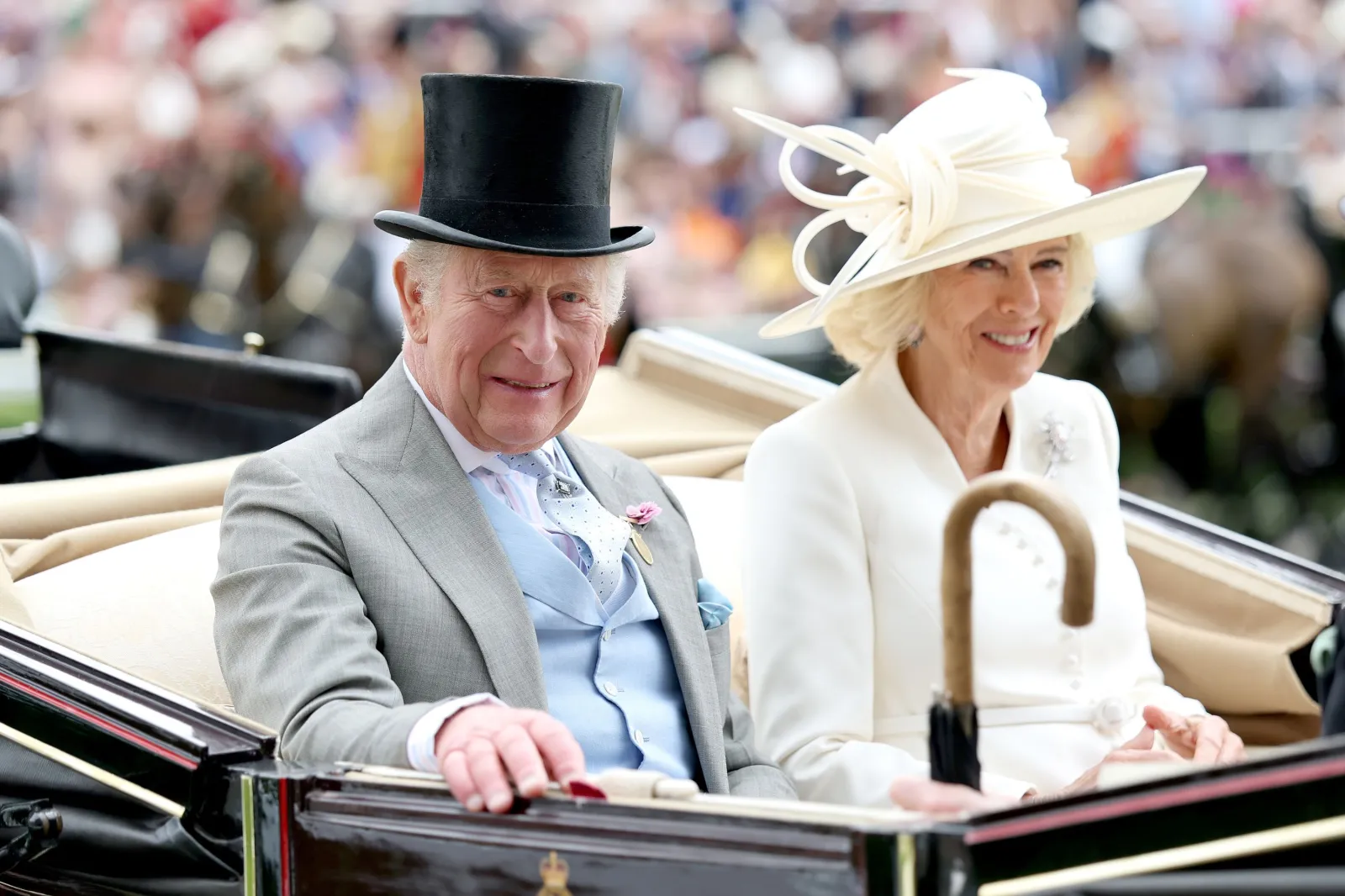 King Charles III and Queen Camilla smile from their royal carriage at Ascot Racecourse, in Ascot, England, on June 17, 2026.