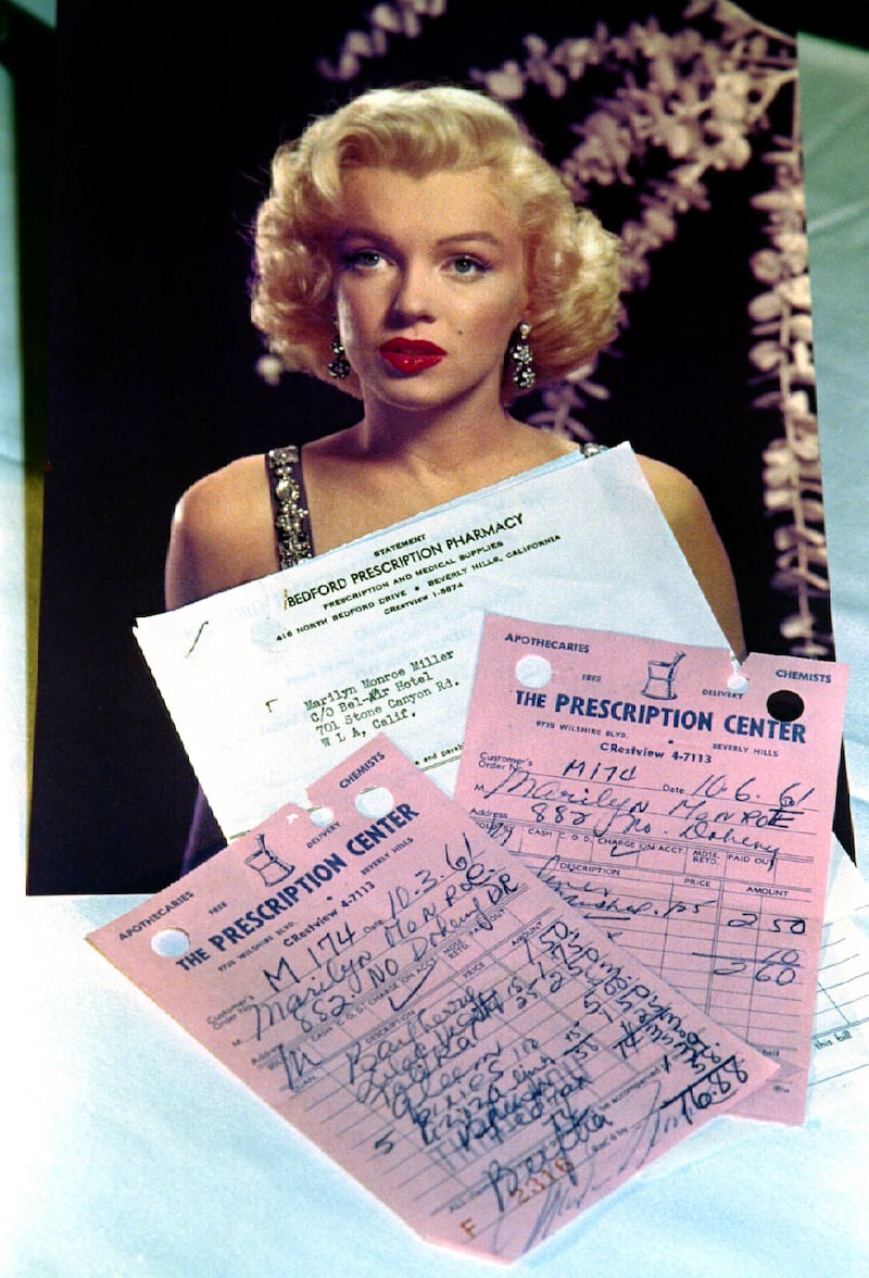 Several of Marilyn Monroe's prescription medicine receipts dated from 1961 are displayed with her photograph.