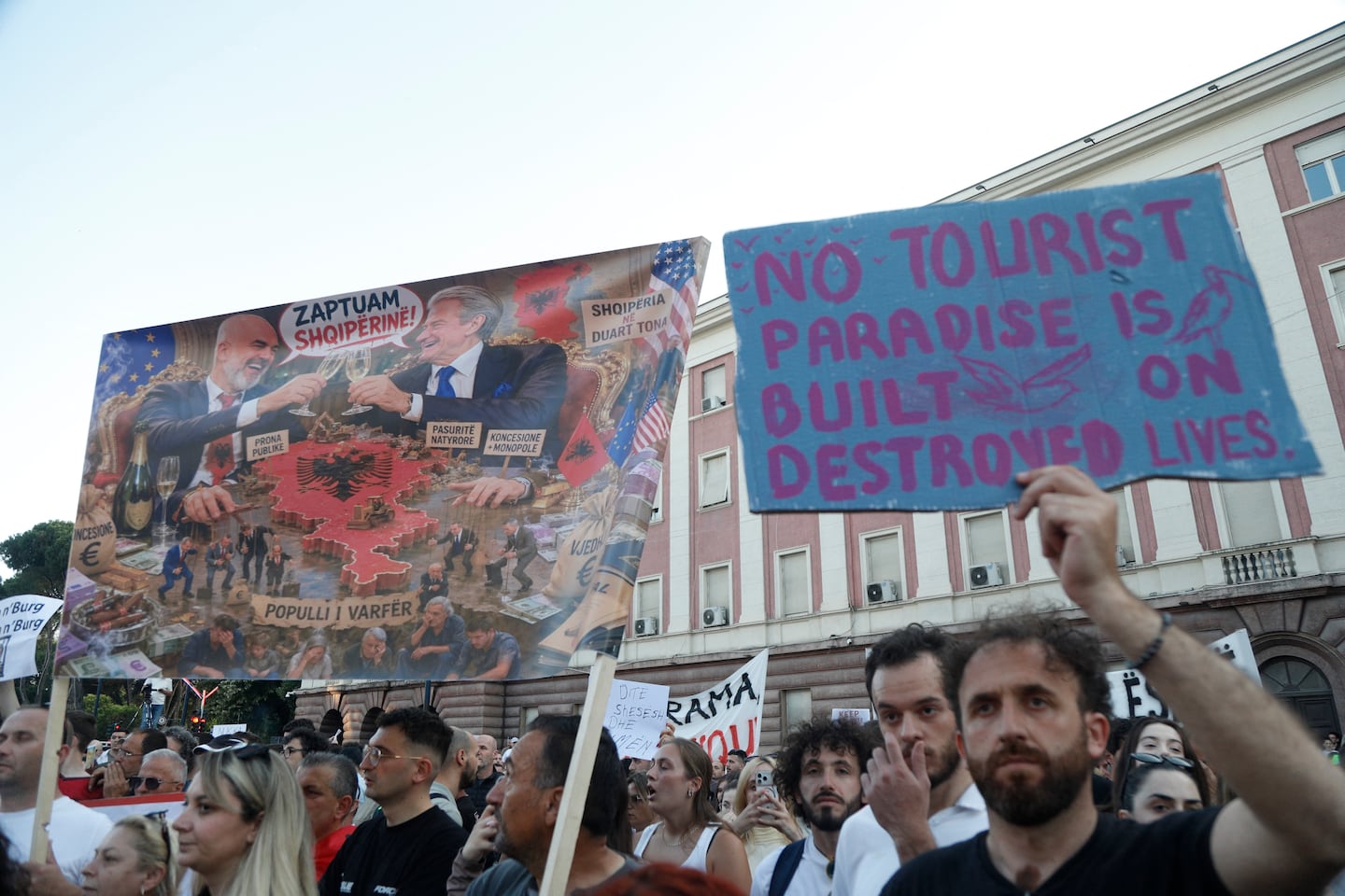 A protester held a sign at Wednesday's protest that read, "No tourist paradise is built on destroyed lives."