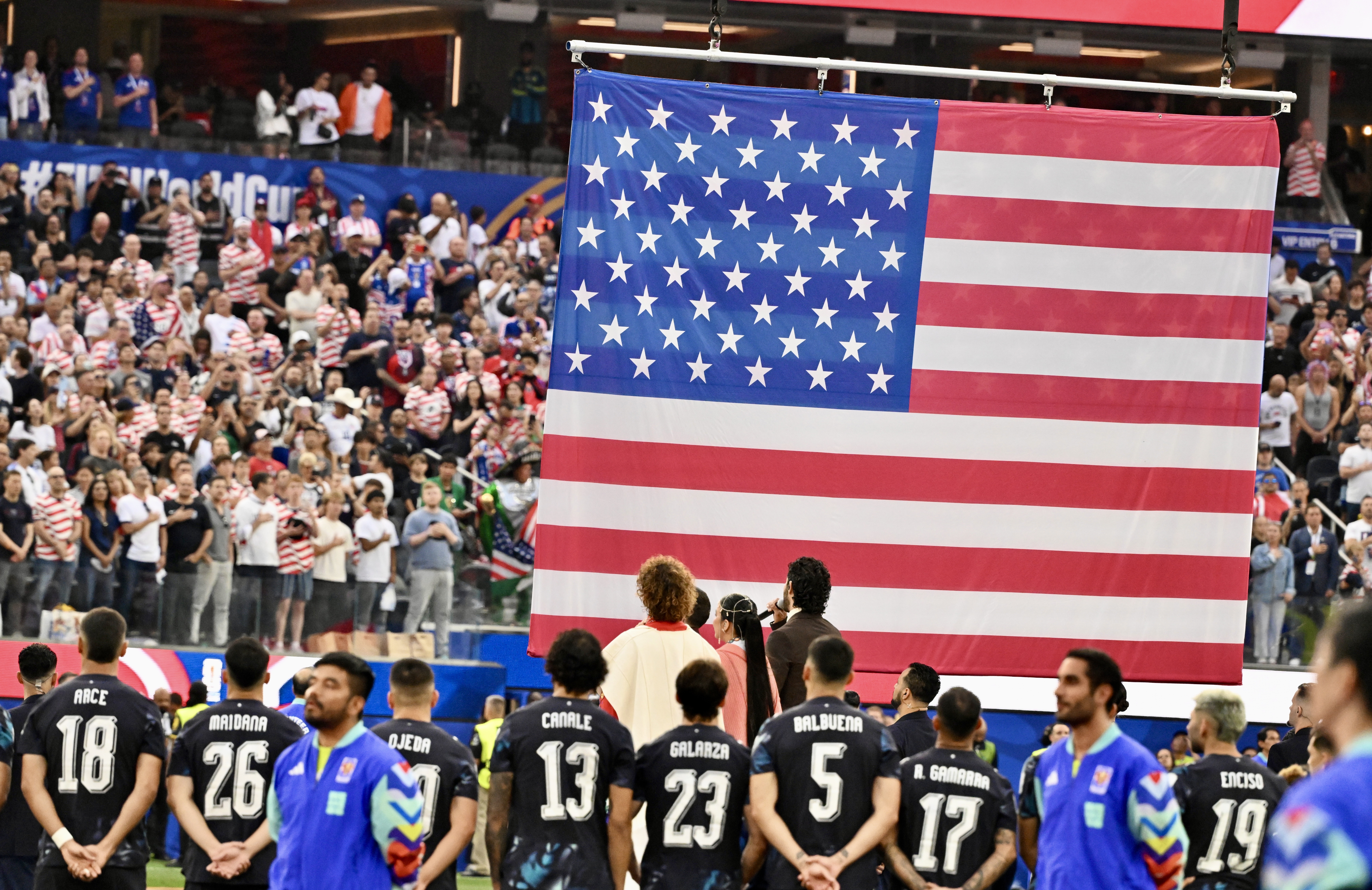 Fans and players look on during the national anthem prior...