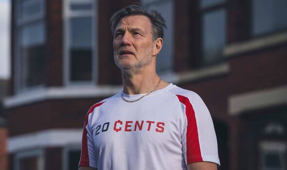Man standing in the street wearing a football shirt