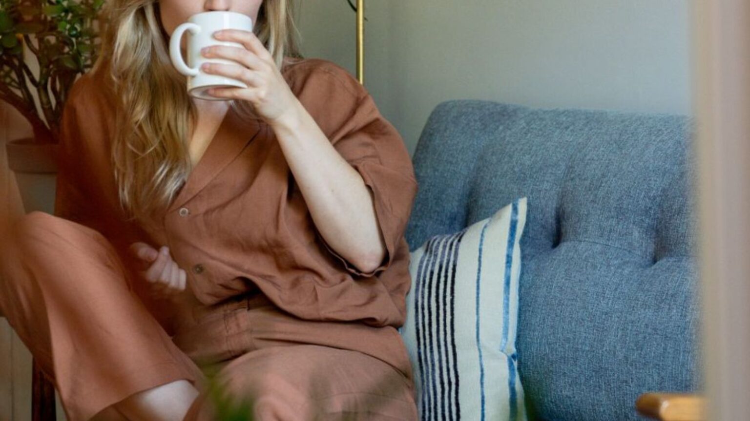 Student’s School Trip Ends in Tears After Famous Celebrity Mistakenly Lashes Out at Her Woman drinking from a mug while sitting on her couch