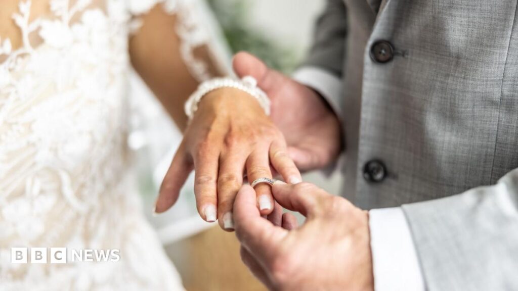 A man puts a ring on a bride's finger