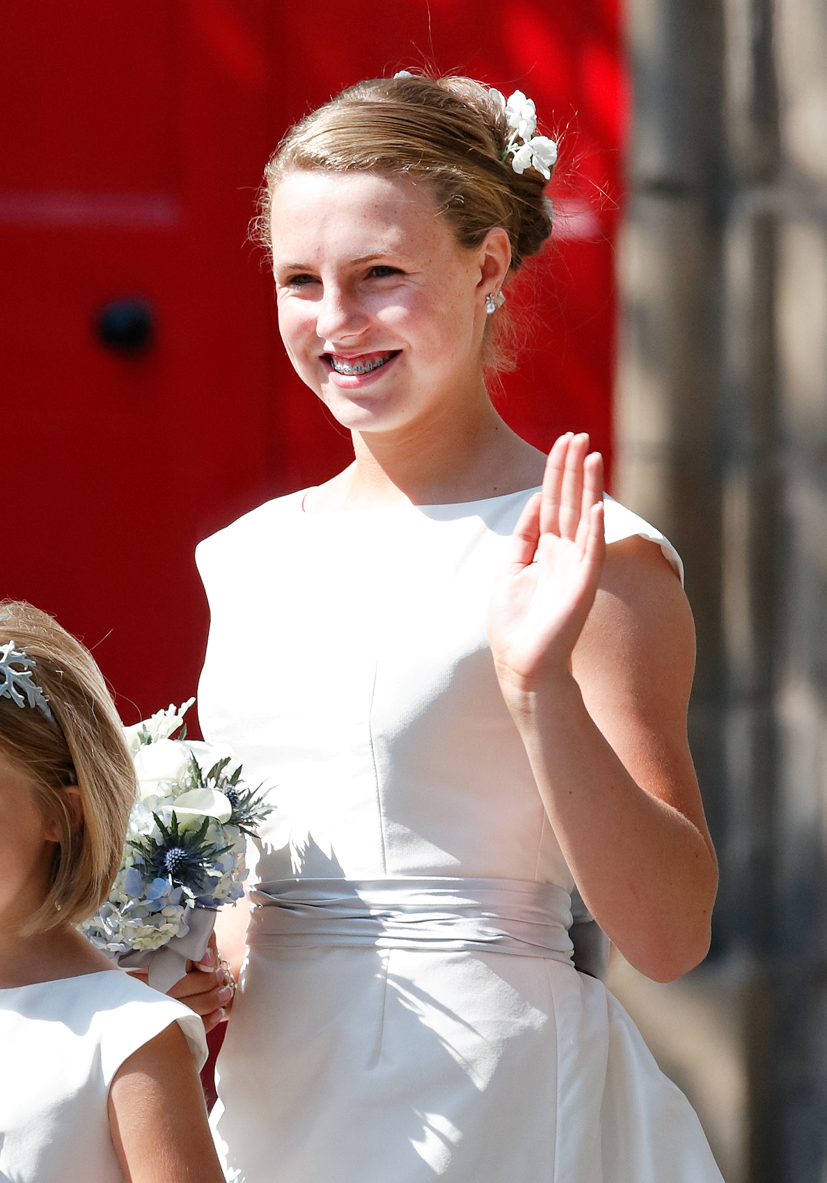 Stephanie Phillips in a white dresswaving at Zara Tindall's wedding