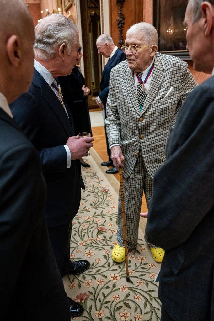 King Charles talking to David Hockney who wears yellow crocs