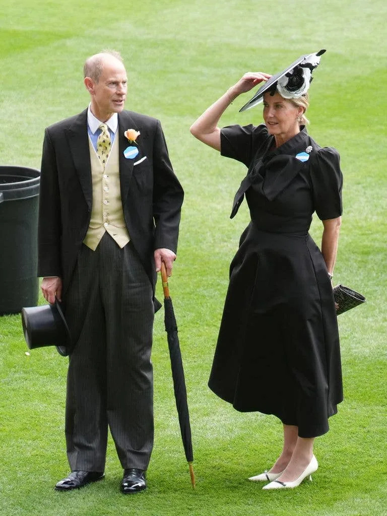 The Duchess of Edinburgh in a black dress holding onto her hat at Royal Ascot