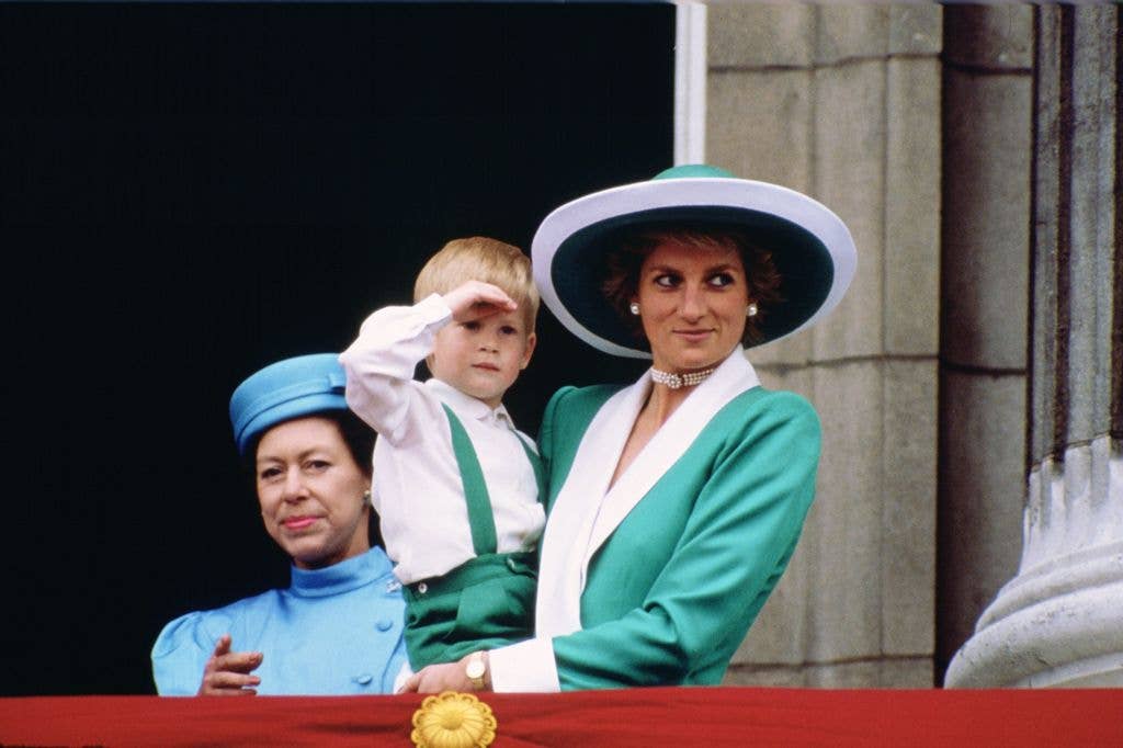 Princess Diana, holding a young Prince Harry in her arms as she watches Trooping the Colour with Princess Margaret from the balcony of Buckingham Palace  in 1988