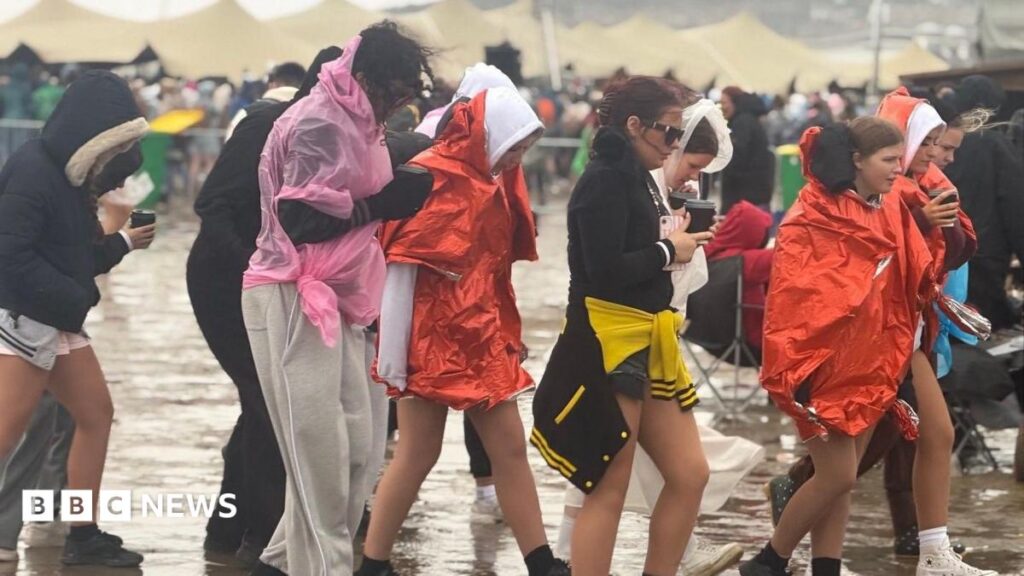 ‘Summer Fest at the Beach was like scene from Final Destination’ Group of women walking from left to right. They are mostly wearing shorts, but have rain ponchos.