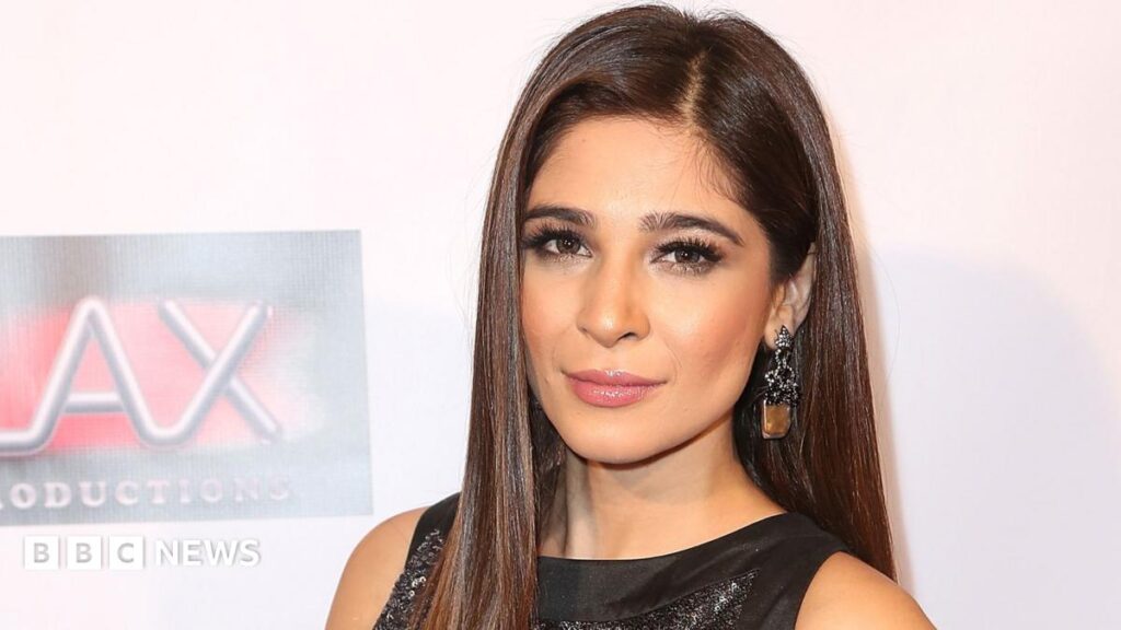 Image-based abuse is not just nudes, warns actress Headshot of a woman with long, straight, dark brown hair looking at the camera. She is wearing a black, sequinned dress and large earrings.