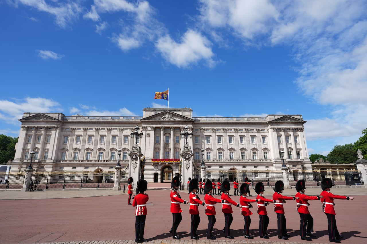 Soldiers march near the entrance to a palace.
