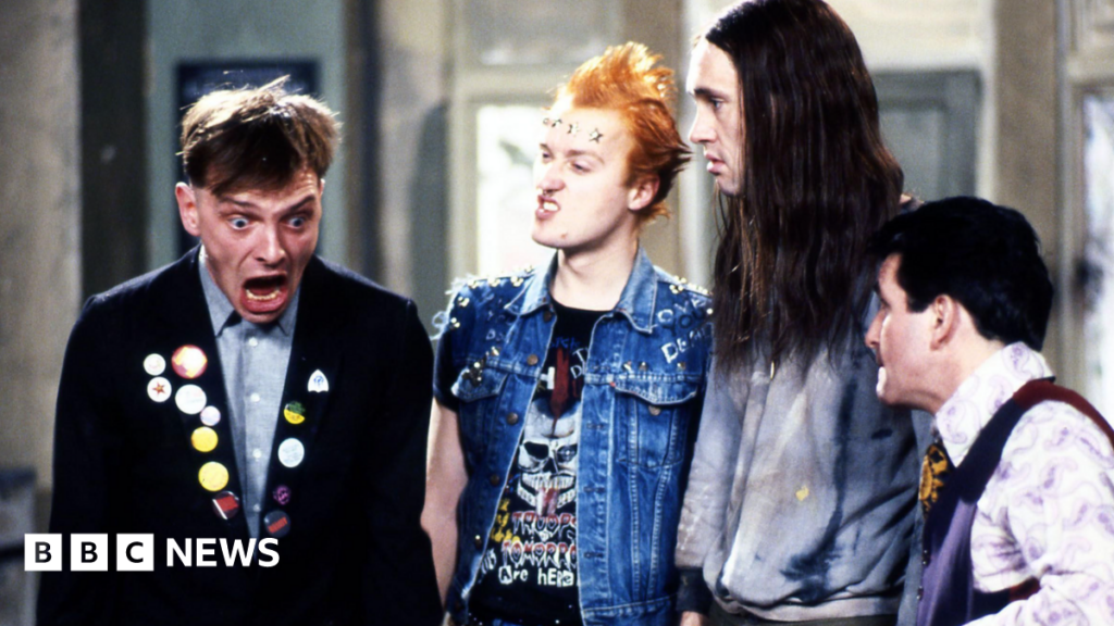 Young Ones star Nigel Planer remembers ‘extraordinary’ Rik Mayall An image from sitcom The Young Ones, showing Mayall, Ade Edmondson, Planer and Christopher Ryan. Mayall, in character wearing a dark jacket including badges, is looking shocked and the others are looking at him.