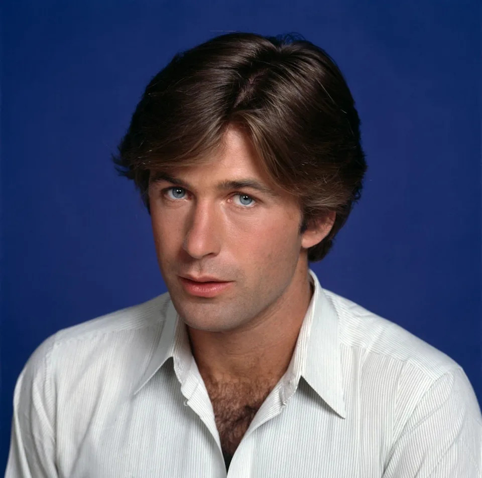 Person wearing a collared shirt poses against a plain background