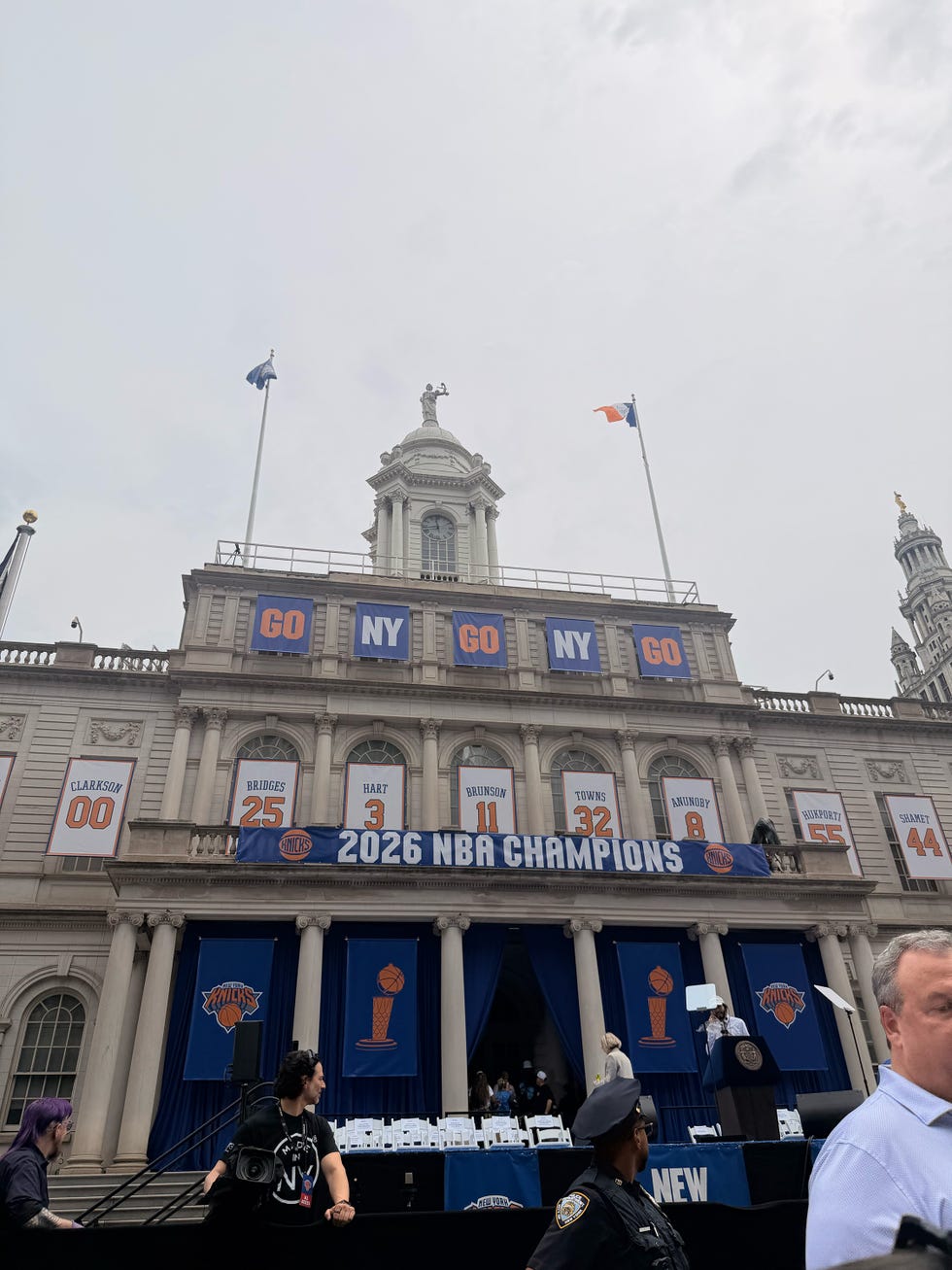 City Hall decorated for Knicks' 2026 NBA Championship celebration with banners and flags.