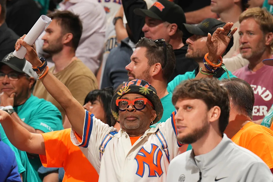 Spike Lee with his hands raised in the air at Game 1 between the New York Knicks and the San Antonio Spurs.