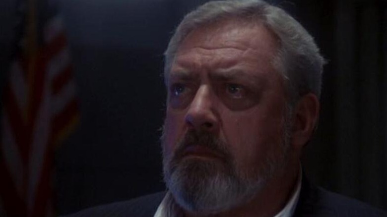 Steve Martin (Raymond Burr) looks emotional by an American flag in Godzilla 1985
