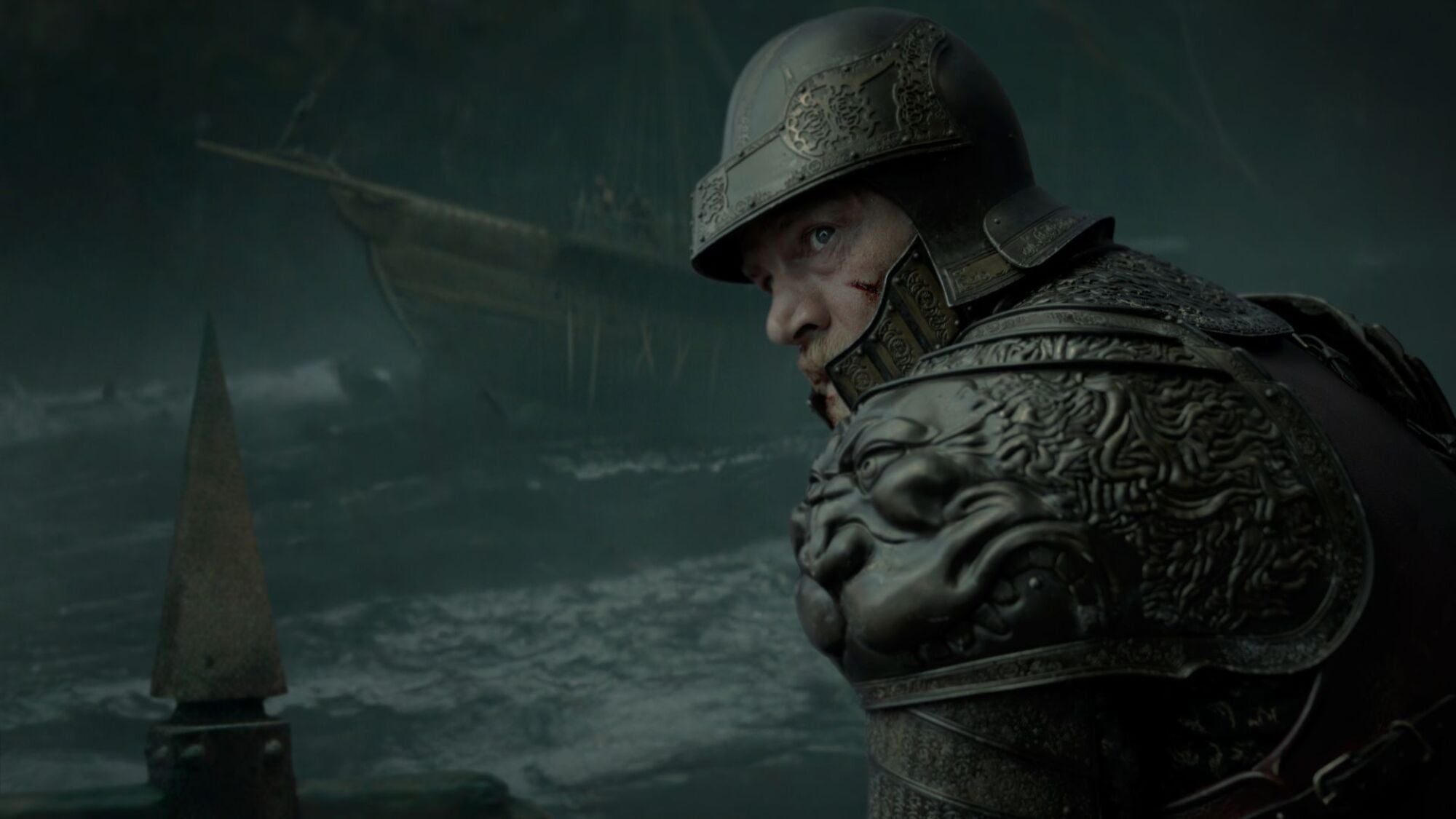 A man in armour heads in to battle on a ship.