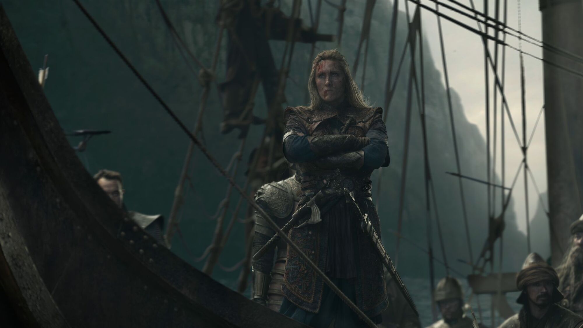 A woman stands on the prow of a ship.