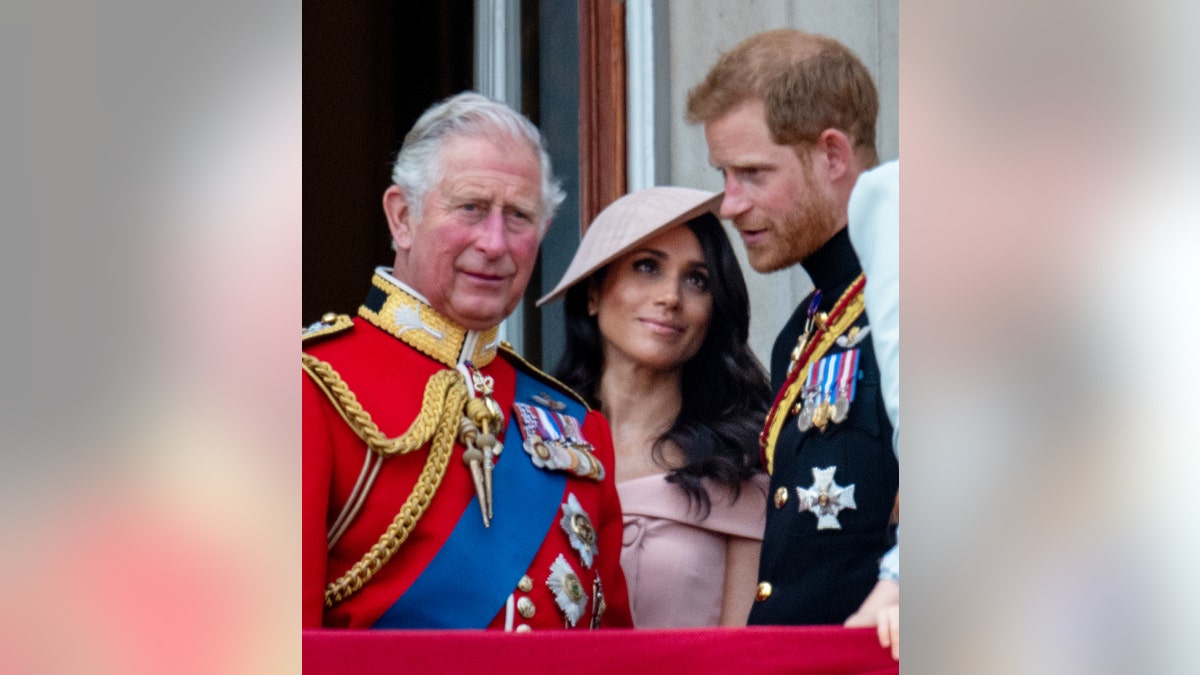 Prince Charles in red military suit with Prince Harry and Meghan Markle on Buckingham Palace balcony