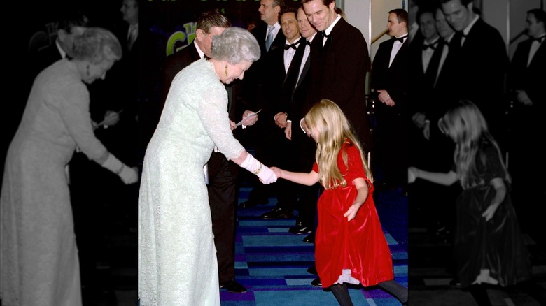 Queen Elizabeth II shaking Taylor Momsen's hand at a film premiere in 2000