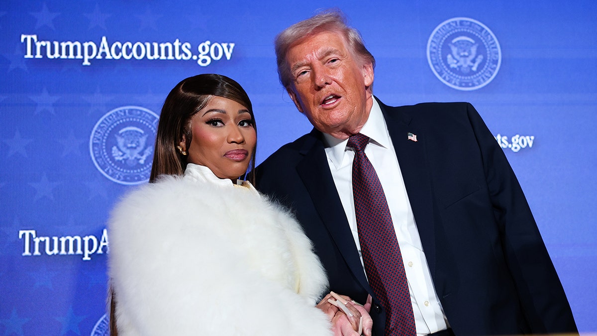 Musician Nicki Minaj standing with President Donald Trump on stage at Andrew W. Mellon Auditorium