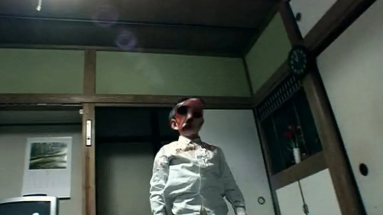 Shuta Kambayashi as the manifestation of the demon Kagutaba, appearing as a young boy in a white collared shirt as his face distorts into a demon.