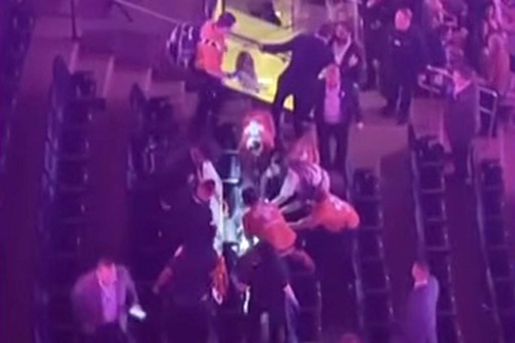Security and concert-goers assist an injured Paul Keuker at Madison Square Garden.