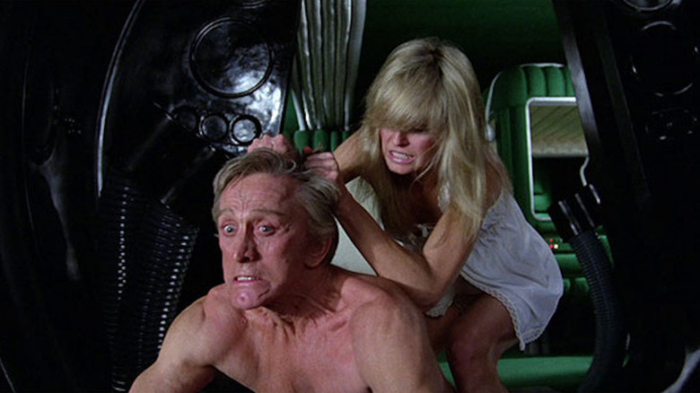 Alex (Farrah Fawcett) pulls a bare-chested Adam (Kirk Douglas) by the scalp in Saturn 3