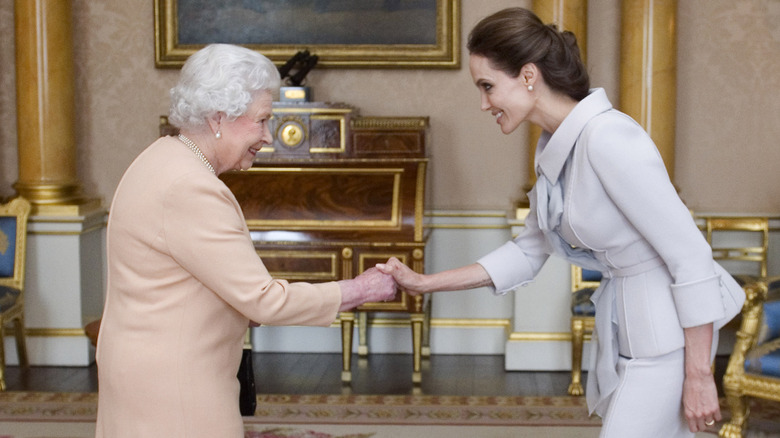 Queen Elizabeth II shaking the hand of Angelina Jolie in 2014