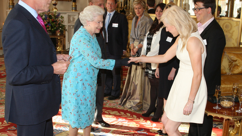 Queen Elizabeth II shaking Ellie Goulding's hand at Buckingham Palace in 2011